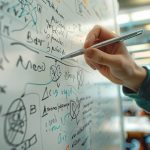 Main écrivant sur un tableau blanc, traçant un diagramme complexe et des équations pour une session de brainstorming ou de stratégie.