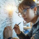 Jeune personne (étudiante ou ingénieure) concentrée, portant des lunettes et dessinant un organigramme ou une stratégie complexe sur un tableau blanc.